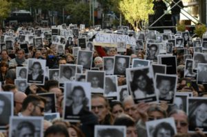 Participants in a memorial ceremony on the 22nd anniversary of the AMIA Jewish center bombing in Buenos Aires hold photos of some of the 85 victims, July 18, 2016. (Leonardo Kremenchuzky)
