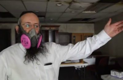 Rabbi Moshe Liberow wears a gas mask in a video showing the damage to the sanctuary at Chabad Colorado Springs.