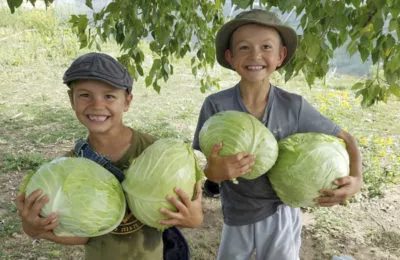 Brothers Israel and Aiden Camire proudly display cabbages produced on the family's farm.