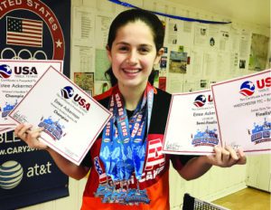 Estee Ackerman holding certificates representing the five medals she won in this month's US Open in table tennis.