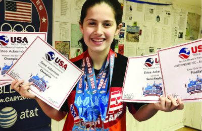 Estee Ackerman holding certificates representing the five medals she won in this month's US Open in table tennis.