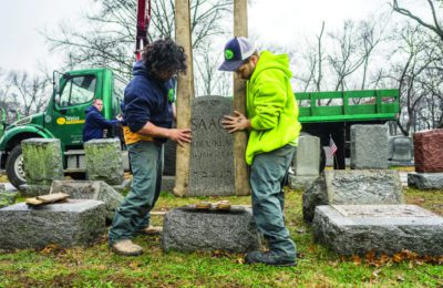 Workers place headstones back on their bases on Feb. 21, 2017 at Chesed Shel Emeth Cemetery in St. Louis. (James Griesedieck/St. Louis Jewish Light)