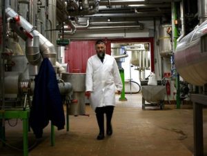 Rabbi Avraham Schwarz inspecting a cheese factory in Denmark. (Lars Skaaning)