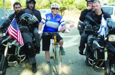 Jenny Paddock rides with Israeli police officers.