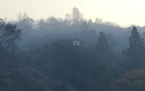 Surrounded by blackened vegetation, Camp Newman's iconic hillside Jewish star survived.