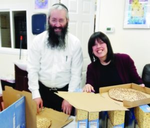 Rabbi Moshe and Zeldie Liberow prepare matzah packages.