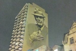 A painting of Leonard Cohen towering above Crescent Street in downtown Montreal.