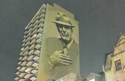 A painting of Leonard Cohen towering above Crescent Street in downtown Montreal.