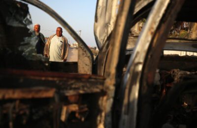 Palestinians stand next to a vehicle, where volunteers from the World Central Kitchen, including foreigners, were killed in an Israeli airstrike, according to the NGO, in Deir Al-Balah, in the central Gaza Strip, April 2, 2024. (Majdi Fathi/NurPhoto/Getty)