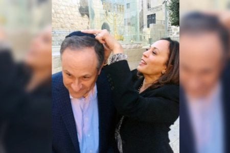 Kamala Harris affixes a kippah to the head of her husband, Douglas Emhoff, as they visit the Western Wall, Jerusalem, November 2017. (Halie Soifer)