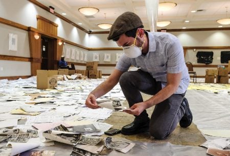 Josh Furman is shown sorting through documents rescued from Hurricane Harvey floodwaters at Congregation Beth Yeshurin in Houston. (Michael Duke/Jewish Voice Herald)