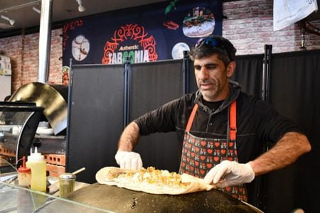 Raif Rashed, an Israeli Druze and the owner of Taboonia, wraps up a pita with labneh. (Jackie Hajdenberg)