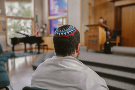 A Jewish man prays in a synagogue sanctuary. (Illustrative)