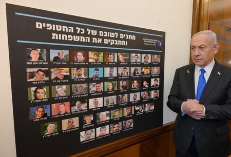Israel Prime Minister looks at a poster of the hostages who still remain in Gaza as he speaks to his cabinet ahead of the implementation of the ceasefire deal, Oct. 9, 2025. (Avi Ohayon/GPO)