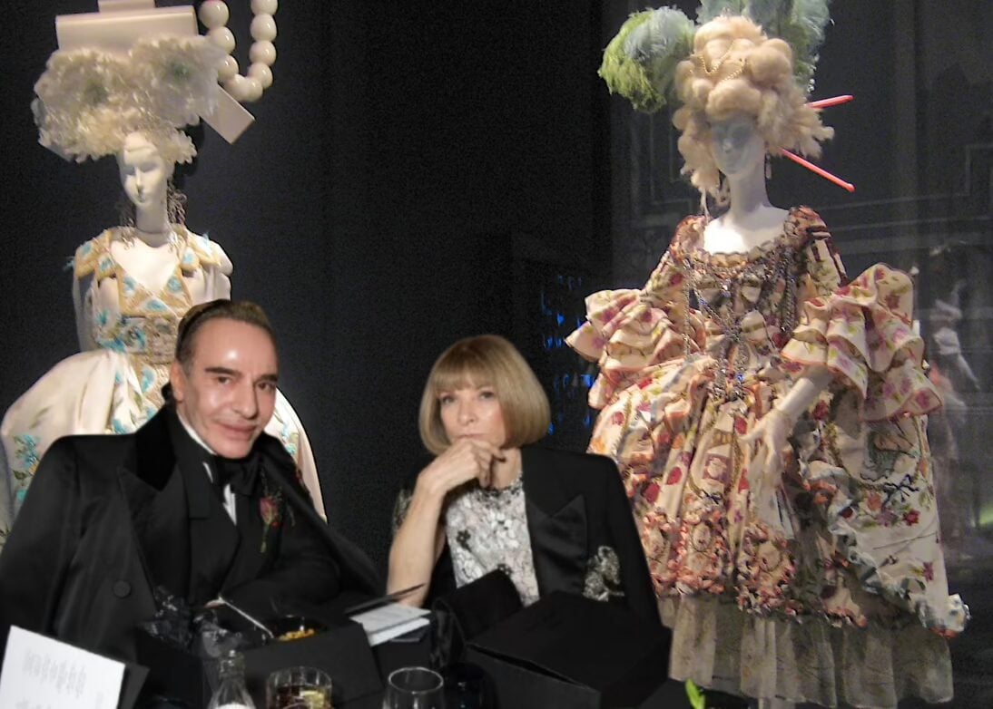 John Galliano and Anna Wintour pictured in 2021; in the background are Galliano-designed gowns on exhibit at the Pushkin State Museum of Fine Arts in Moscow. (Getty Images)