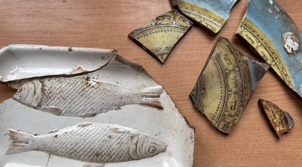 Fragments of a gefilte fish dish and a Passover plate that were found at the Great Synagogue excavation site. (Shira Li Bartov)